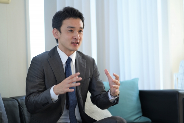 スーツを着た男性が説明する様子
