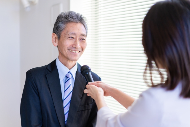 スーツ姿の男性にマイクを装着
